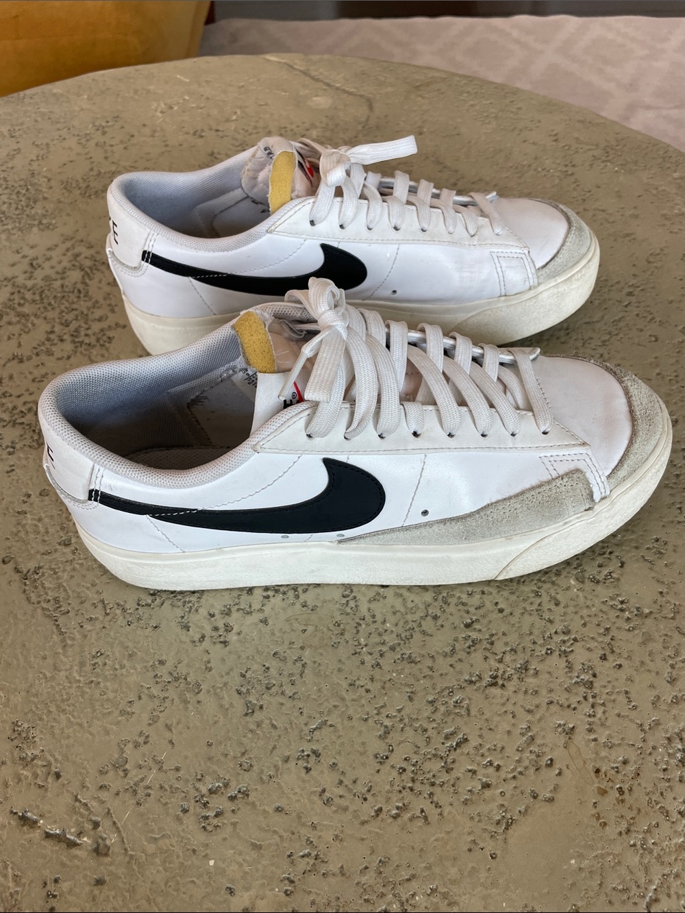 Nike White Low-Top Sneakers with Black Swoosh and Yellow Tongue Tab